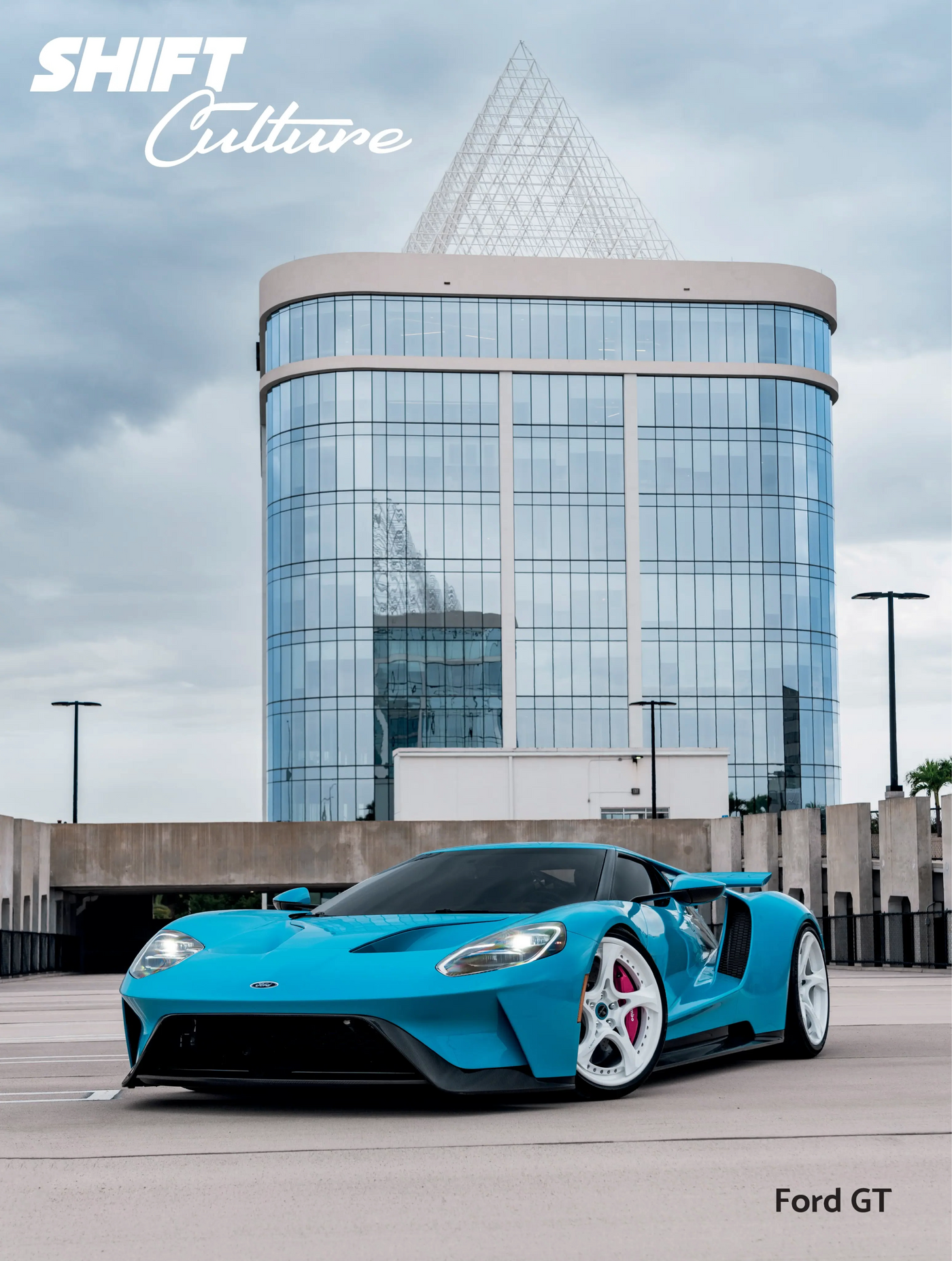 Blue Ford GT car in front of a modern building with 'SHIFT Culture' branding.