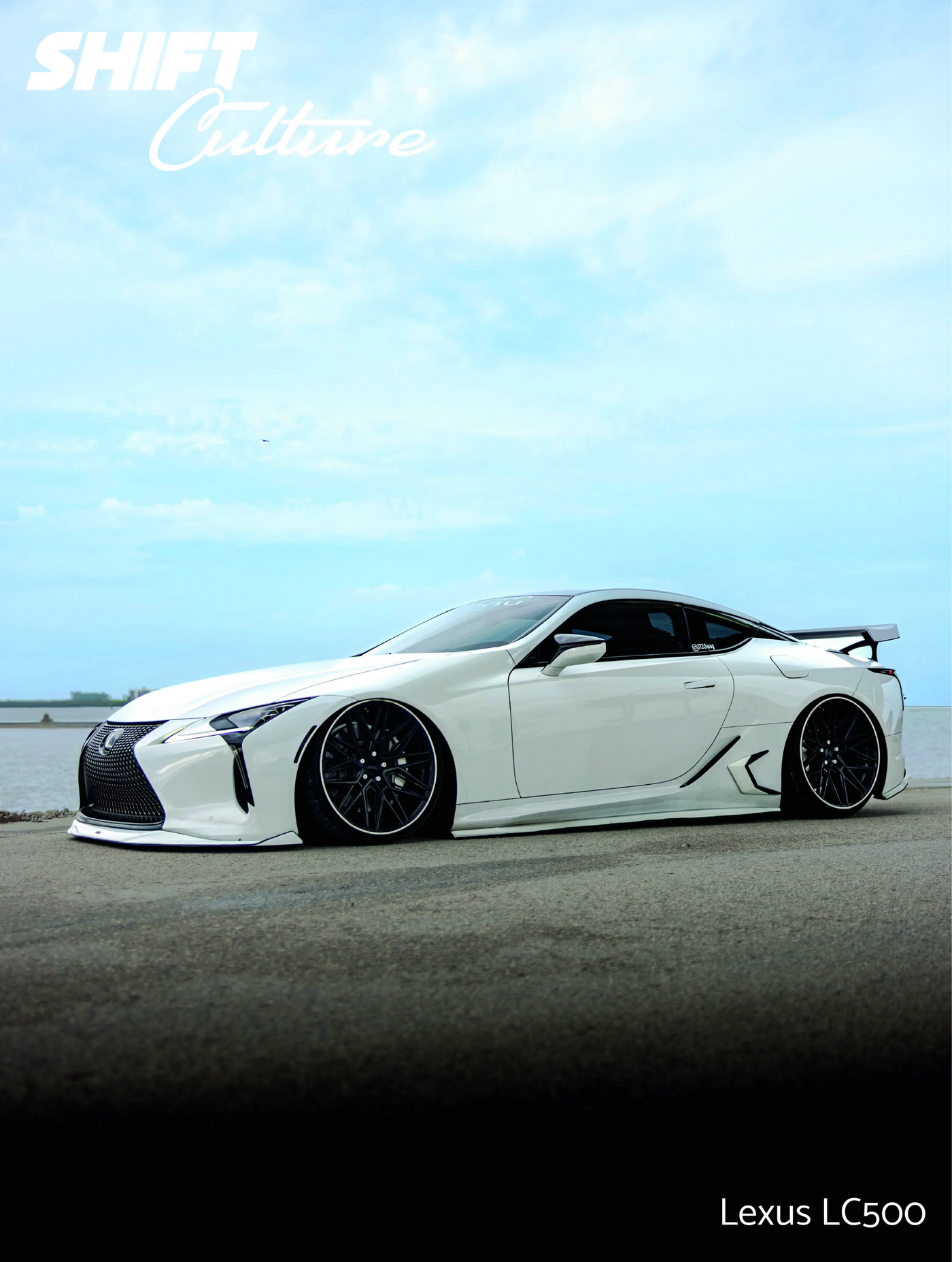 White Lexus LC500 car on a road with a clear sky background
